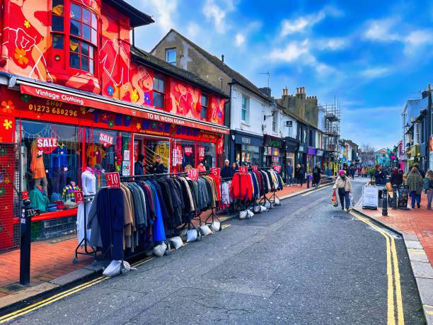 vibrant retro looking store in Brighton England Brighton, United Kingdom - March 04 2022: a clothing store in vibrant painted colors with people walking on the street brighton england stock pictures, royalty-free photos & images