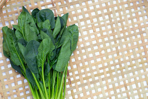 Fresh spinach in bamboo weaves plate