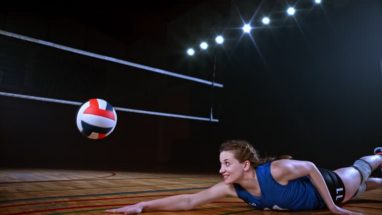 SLO MO Female player in blue jersey diving to the ground and saving the ball