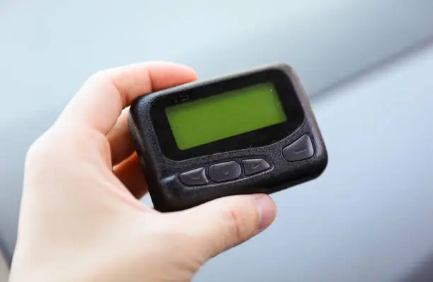 Photo of Pager is a small wireless device that receives and displays numeric or text messages, symbolizing the era of technological advancements in communication and transition from analog to digital device