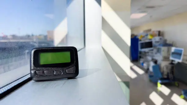 Photo of Pager is a small wireless device that receives and displays numeric or text messages, symbolizing the era of technological advancements in communication and transition from analog to digital device