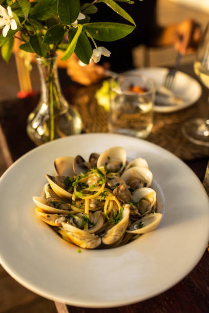 Tasty pasta meal with clams on dinning table at the restaurant outdoors, ready to eat.