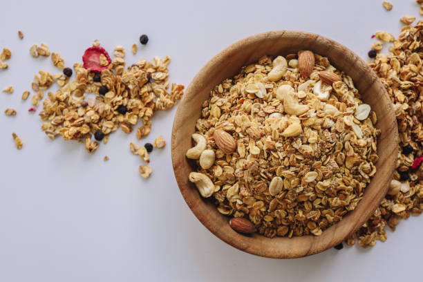 istock Granola with nuts and almonds on a white background, cereal scattered around 1481523007