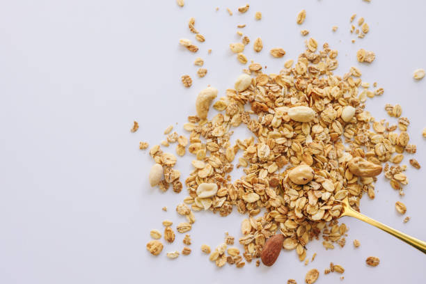 istock Granola on spoon isolated on white background, copy space. Healthy snack or breakfast concept - homemade granola with grains and nuts 1481523008