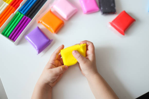 istock Child hands molding modeling clay or plasticine on white table 1481523058