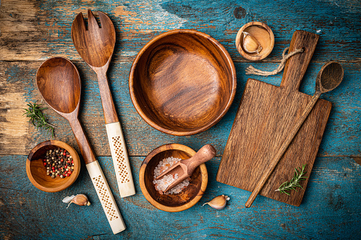 Old wooden kitchen utensils or cooking tools and bowls on wooden background, top view, flat lay. Kitchenware collection with copy space. Cooking background.