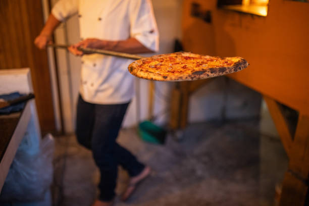 istock Chef taking pizza out of the oven 1481527598
