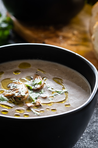 Vegan Cream of Mushroom soup garnished with mushrooms, olive oil and parsley.