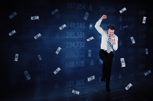Happy businessman using a cellphone while standing with flying money and virtual screen background