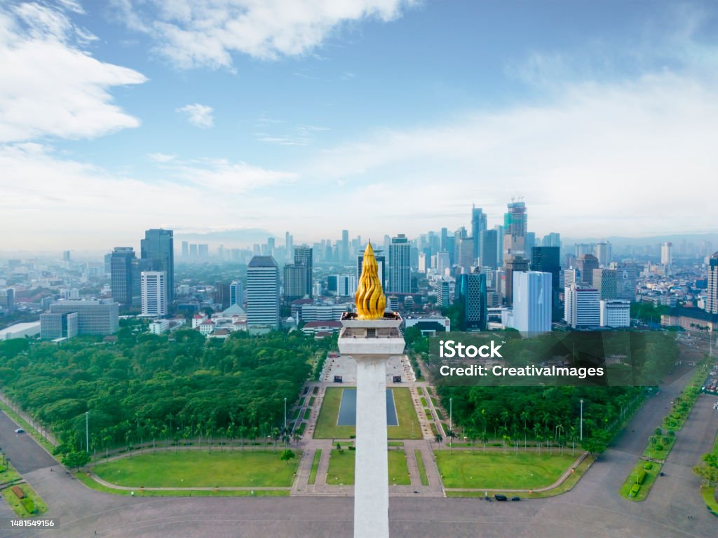 Drone view of National Monument peak with cityscape JAKARTA - Indonesia. November 01, 2022: Drone view of National Monument peak with Jakarta cityscape at misty morning Jakarta Stock Photo