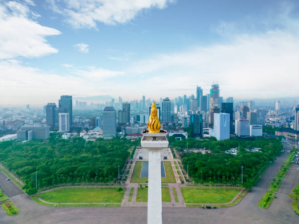 Drone view of National Monument peak with cityscape JAKARTA - Indonesia. November 01, 2022: Drone view of National Monument peak with Jakarta cityscape at misty morning merdeka square stock pictures, royalty-free photos & images