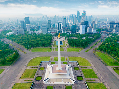 JAKARTA - Indonesia. November 01, 2022: Beautiful landscape of National monument with misty Jakarta cityscape at morning time