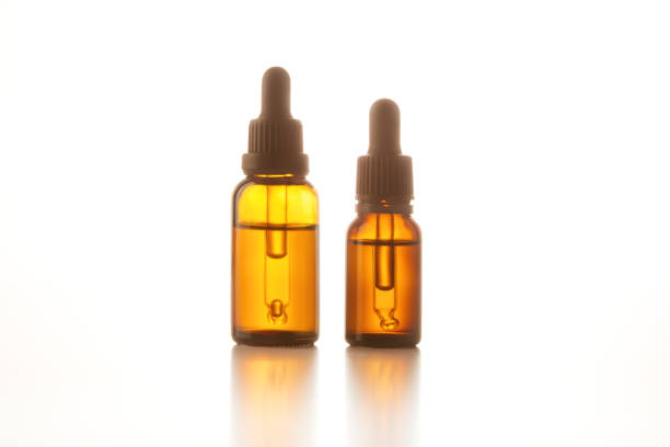 istock Two brown vials with black dropper caps isolated on white. 1481554362
