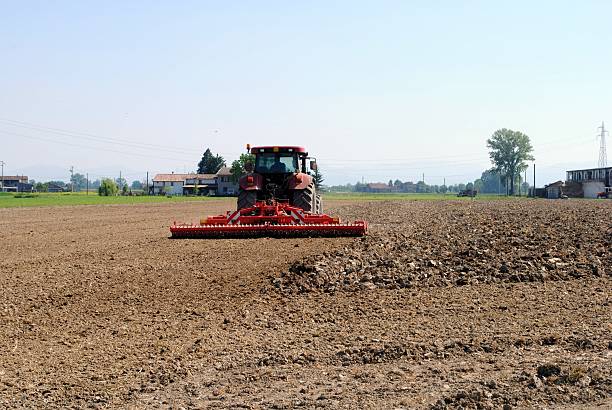 red tractor prepares soil red tractor prepares soil for seed in farmlands geochelone yniphora stock pictures, royalty-free photos & images