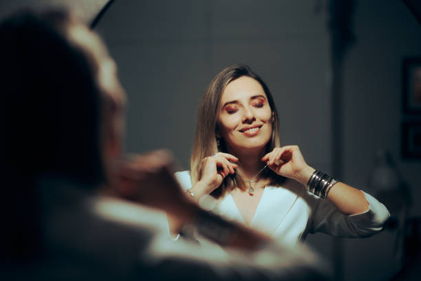 펜던트가 달린 새 목걸이를 착용한 행복한 웃는 여성 - necklace women jewelry mirror 뉴스 사진 이미지