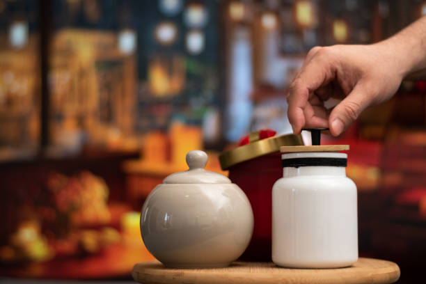 Hand open a Mug of sugar and salt containers style vintage over a table in night restaurant with selective focus and bokeh background Hand open a Mug of sugar and salt containers style vintage salt pepper ingredient black peppercorn stock pictures, royalty-free photos & images