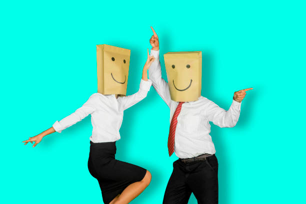 Two unknown business people dancing on studio Two unknown business people looks happy while dancing together in the studio with tosca background anonymous businessman with paper bag on his head stock pictures, royalty-free photos & images