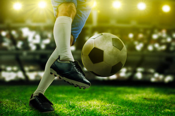 istock Soccer player foot dribbling a ball in stadium 1481560738