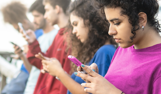 Closeup of a Millennial Brazilian Friends Group Using Modern Smartphones - Startup Friendship Teamwork Concept - Selective Focus.