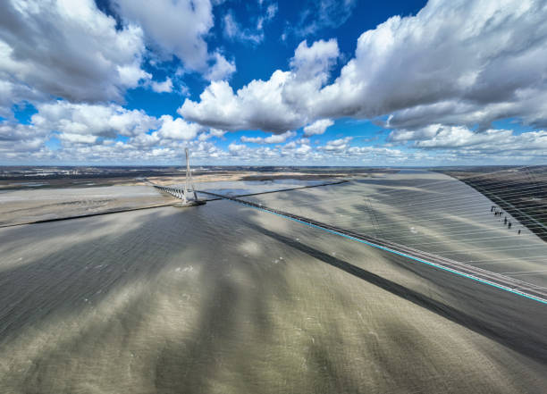 Le Havre, France - March 19, 2023: Pont de Normandie - Normandy Bridge cable-stayed road bridge over the river Seine linking the city of Le Havre to Honfleur City in Normandy, Northern France. Dramatic Summer Skyscape over River Seine. Wide Angle Drone Point of View. Total length of Normandy Bridge is approx. 2.100m or 7.000 ft, It's the last bridge to cross the Seine before the Atlantic Ocean in Normandy. Pond de Normanie, Le Havre, Northern France, Europe.