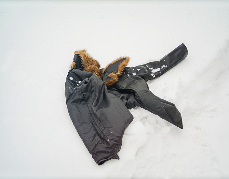 a leather jacket with fur collar abanoned on the snow, outdoor winter scene