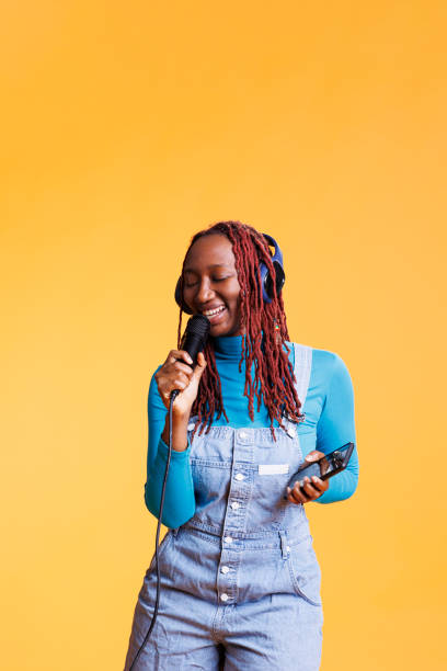 istock Happy woman singing live on microphone 1481577805