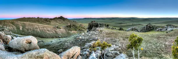 Panorama of Mongolian steppe landscape with rocks at dusk