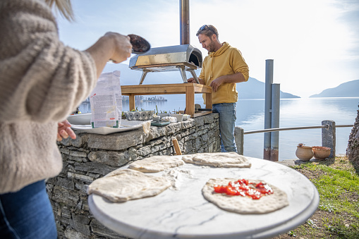 People having a great weekend cooking pizza