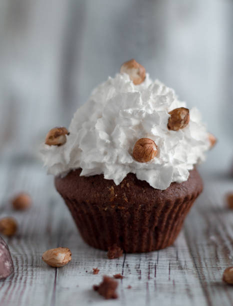 istock Delicious chocolate brownie muffins with nuts and whipped cream 1481581372