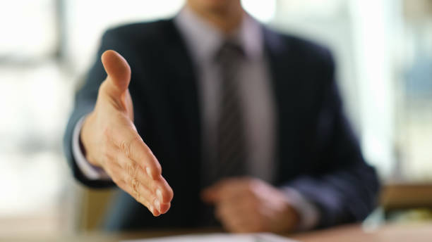 istock Businessman holding out his hand for handshake at work in office closeup 1481581459
