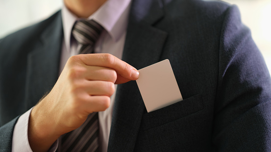 Businessman taking out business card from his jacket pocket closeup. Profitable business meeting and dating concept
