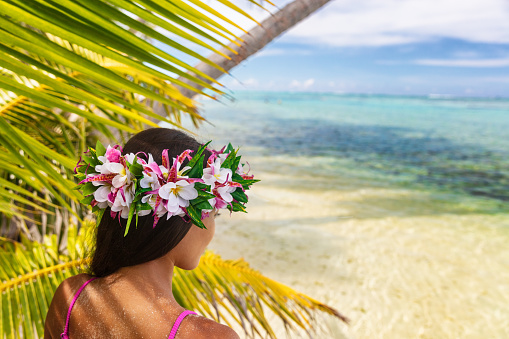 Hawaii beach woman luau dancer relaxing wearing wreath of fresh flowers on Tahiti Bora Bora, French Polynesia.
