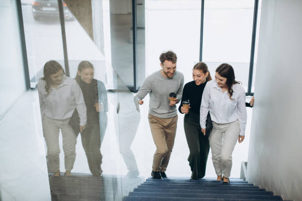 A group of businesspeople walking up the stairs in the modern building, talking. A group of businesspeople walking up the stairs in the modern building, talking. 7944 stock pictures, royalty-free photos & images