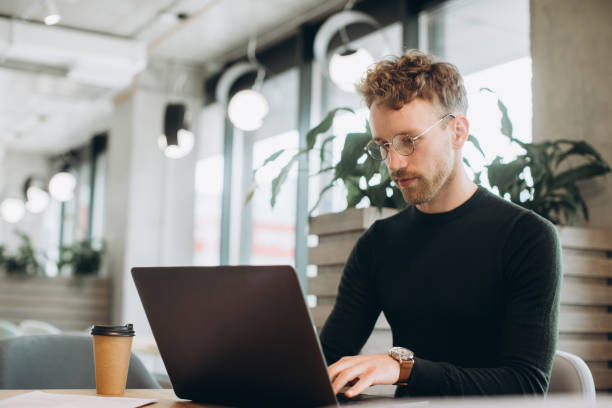 istock Man using laptop sitting at conference table in office 1481584259