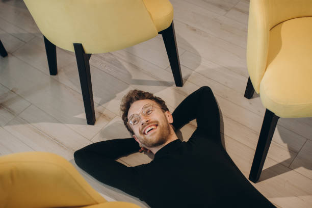 istock Businessman with hands behind head lying on floor in office 1481584275