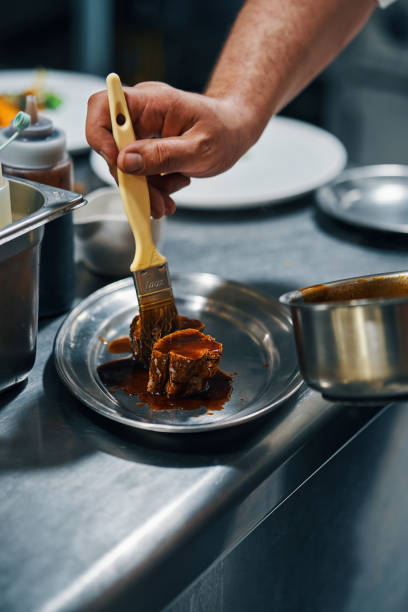 istock cook painting steak with sauce in professional kitchen 1481586064