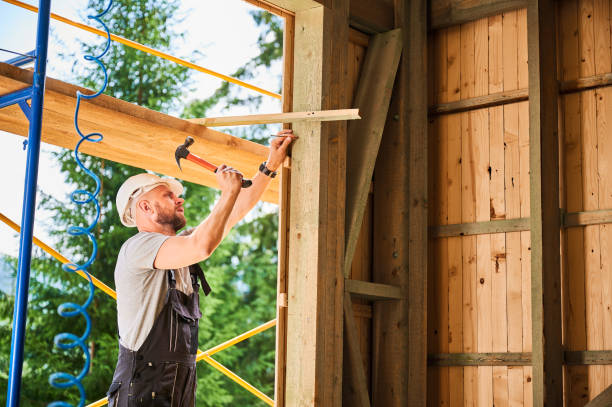 istock Carpenter hammering nail while constructing wooden frame two-story house near the forest. 1481587317