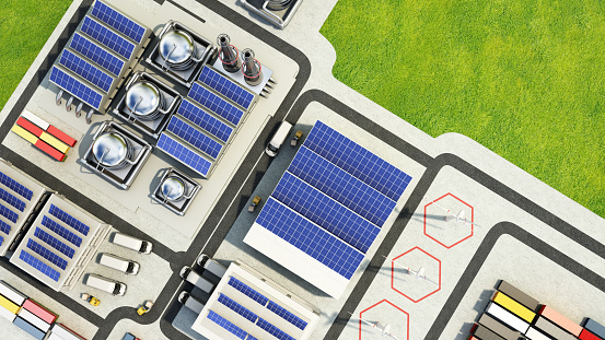 Solar panels installed on factories and buildings of an industrial zone. Copy space on the top right corner. Sustainable energy concept.