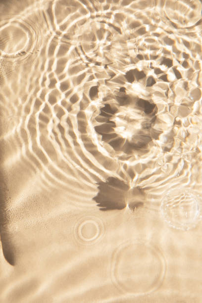 istock Abstract nature textured background, water waves with sun reflection. Clear water with bubbles and circles on beige background 1481589213