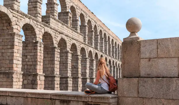tour tourism in Castile and Leon- Segovia with tourist looking at view of Roman aqueduct