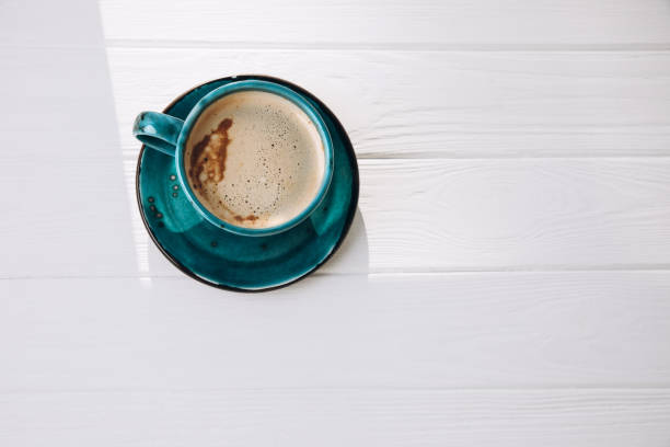 istock Blue mug with coffee, cappuccino on a white wooden background. Top view 1481592201