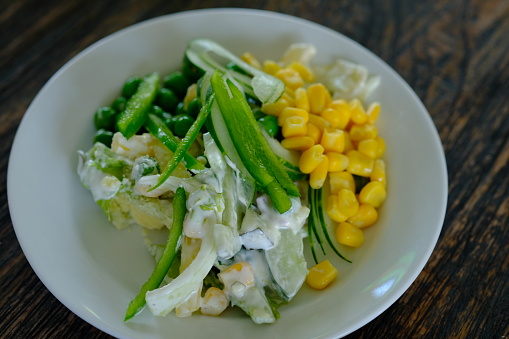 raw vegetable salad with white mayonnaise dressing.