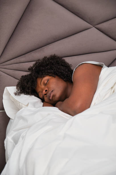 istock African young woman asleep on white sheets in bed. 1481594485