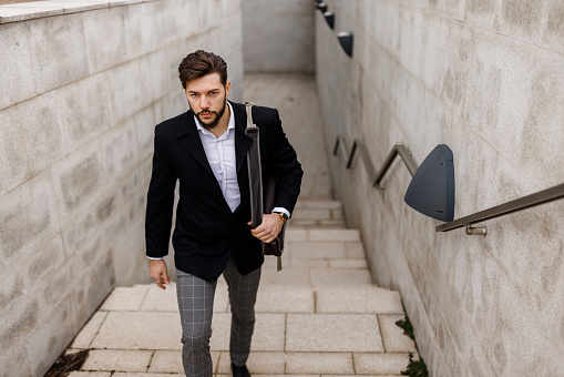 Young businessman moving upstairs while going to work