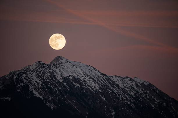 istock Beautiful full moon setting over majestic snow covered mountains. 1481597255