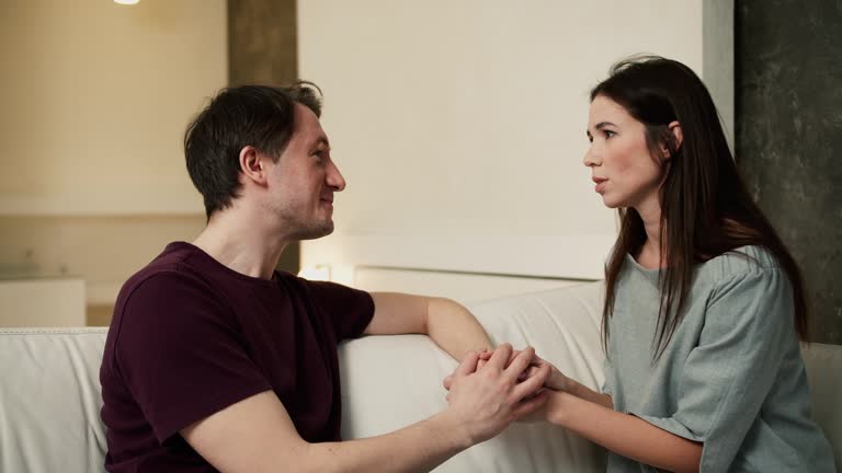 Young wife apologizing or asking husband making peace after quarrel, slow motion