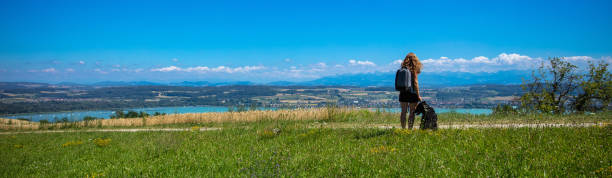 Woman and dog looking at panoramic landscape view