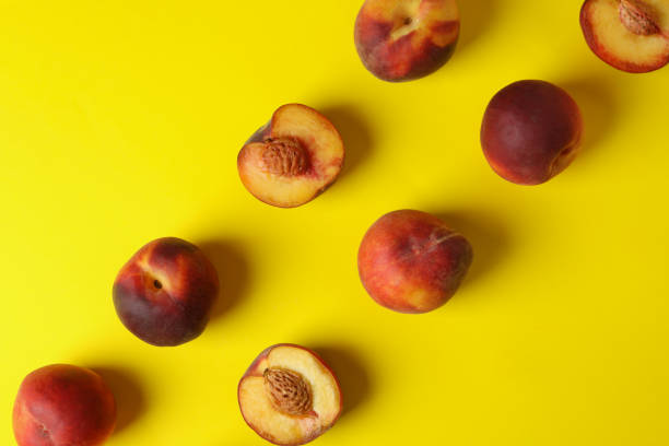 istock Fresh ripe peach fruits on yellow background 1481607100