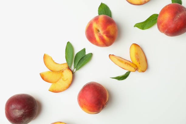 istock Ripe peach fruits with leaves on white background 1481608284