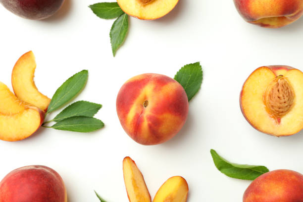 istock Ripe peach fruits with leaves on white background 1481608486